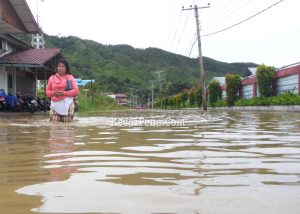seorang warga melintasi banjir di kelurahan pondok batu kecamatan sarudik | Foto: Dom